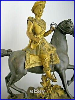 Grande pendule à la cavalière ou au cavalier en bronze doré et patiné