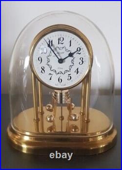 Horloge à poser Schmid mécanique pendule rotatif 8 jours métal doré sous cloche