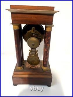 Pendule portique de style Charles X en vois marqueté XX siècle