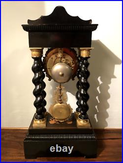 Pendule portique en bois marqueté, noirci et bronze doré. XIXe