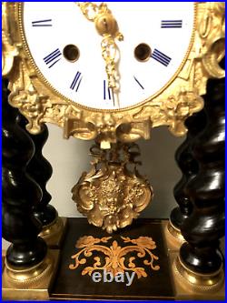 Pendule portique en bois marqueté, noirci et bronze doré. XIXe