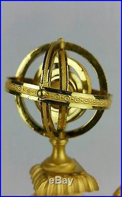 Pendule vers 1820 en bronze doré forme écusson avec sphère armillaire